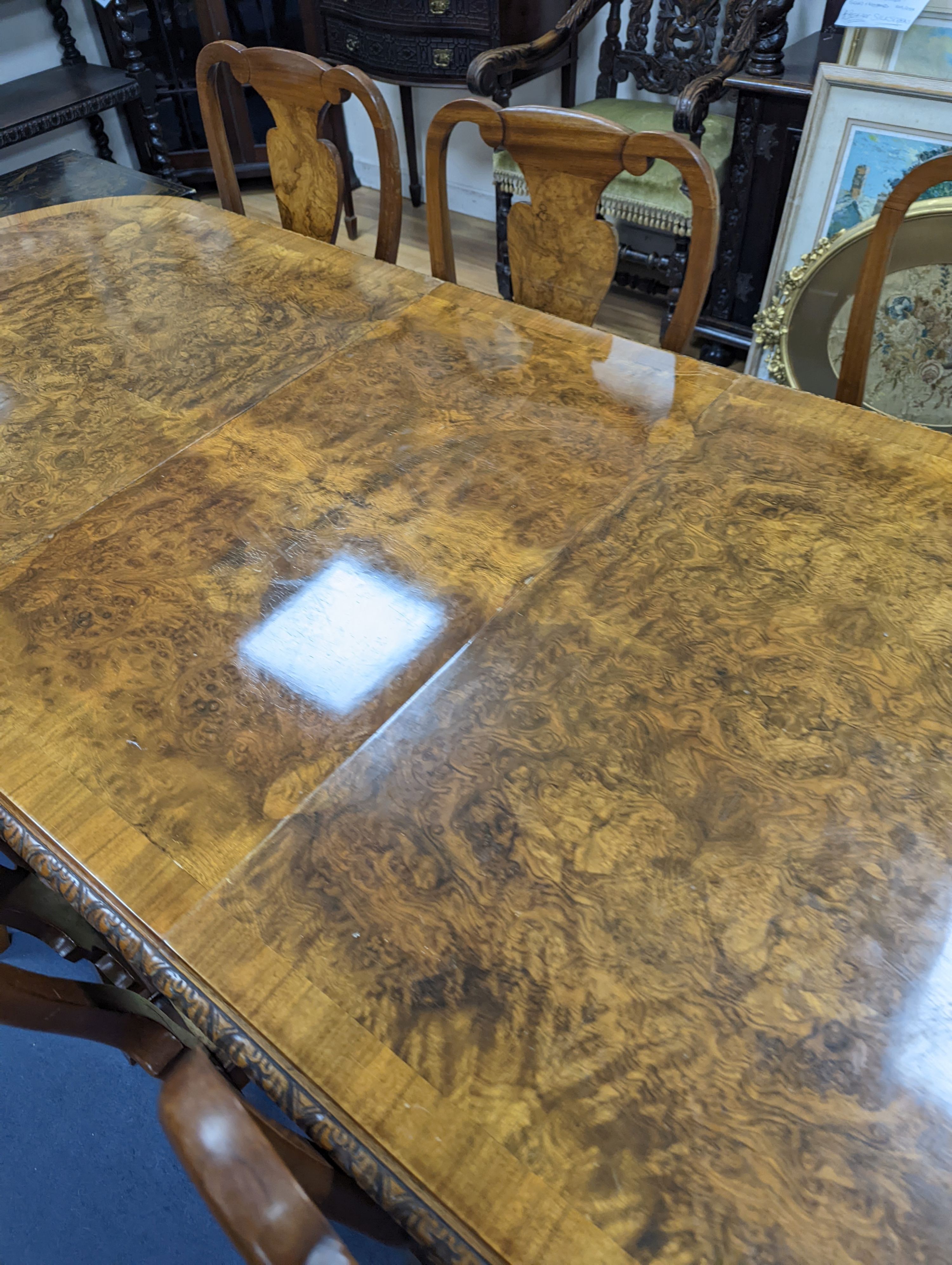 A Queen Anne revival burr walnut dining suite, comprising serpentine sideboard, length 168cm, depth 56cm, height 98cm, extending dining table, 210cm extended, one spare leaf, width 90cm, height 75cm and eight chairs, two